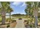 Picturesque outdoor fire pit with seating area and a tranquil lake view framed by palm trees at 528 Fern Tree Dr, Summerville, SC 29486