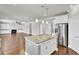 Kitchen with stainless steel refrigerator, stone countertops, kitchen island, and open view of the living room at 528 Fern Tree Dr, Summerville, SC 29486