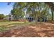 View of the backyard with lush lawn, back of house, patio, and mature trees at 634 Lynne Ave, Charleston, SC 29412
