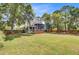 Well-manicured lawn, back of house, patio and mature trees at 634 Lynne Ave, Charleston, SC 29412