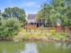 Waterfront backyard featuring a patio, fire pit area, lush greenery, and tranquil lake views at 634 Lynne Ave, Charleston, SC 29412