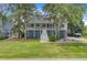Charming raised home featuring lush landscaping, a large yard, and a welcoming front porch at 634 Lynne Ave, Charleston, SC 29412
