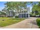 Beautiful elevated home featuring a manicured lawn, elegant staircase, and lush greenery at 634 Lynne Ave, Charleston, SC 29412