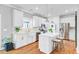 Bright kitchen featuring stainless steel appliances, white cabinets, island with bar stools, and hardwood floors at 634 Lynne Ave, Charleston, SC 29412