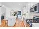 Modern kitchen featuring stainless steel appliances, white cabinets, island with bar stools, and hardwood floors at 634 Lynne Ave, Charleston, SC 29412