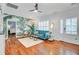 Open living room with hardwood floors, tropical wallpaper, and a stylish blue sofa, seamlessly blending indoor and outdoor aesthetics at 634 Lynne Ave, Charleston, SC 29412