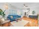 Bright living room showcasing plantation shutters, modern ceiling fan, and a comfortable blue sofa, perfect for relaxation at 634 Lynne Ave, Charleston, SC 29412