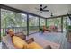 Inviting screened porch with ceiling fans, wicker furniture, plants, and views of the lush surrounding greenery at 634 Lynne Ave, Charleston, SC 29412