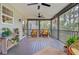 Relaxing screened porch with wicker chairs, a ceiling fan, and views of the natural, lush landscape at 634 Lynne Ave, Charleston, SC 29412