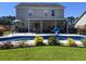 A backyard featuring a covered patio, swimming pool, and well-maintained lawn create an inviting outdoor living space at 7164 Sweetgrass Blvd, Hanahan, SC 29410