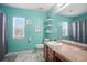 Bright bathroom with wood vanity, large mirror, and turquoise walls at 7164 Sweetgrass Blvd, Hanahan, SC 29410
