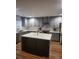Modern kitchen with gray cabinets, a spacious island, stainless steel appliances and wooden floors at 7164 Sweetgrass Blvd, Hanahan, SC 29410