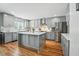 Modern kitchen with gray cabinets, stainless steel appliances, quartz countertops, and a spacious island at 7164 Sweetgrass Blvd, Hanahan, SC 29410