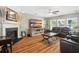 Inviting living room with a fireplace, ceiling fan, wood floors, and a comfortable leather sectional sofa at 7164 Sweetgrass Blvd, Hanahan, SC 29410