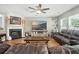 Spacious living room with a fireplace, ceiling fan, wood floors, and a comfortable leather sectional sofa at 7164 Sweetgrass Blvd, Hanahan, SC 29410