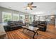 Open-concept living room with wood floors, comfortable leather sofas, and view to a modern kitchen at 7164 Sweetgrass Blvd, Hanahan, SC 29410