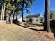 A spacious backyard featuring mature trees and an enclosed sunroom at 7277 Sweetgrass Blvd, Hanahan, SC 29410