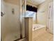 Bright bathroom featuring a glass shower, and soaking tub with purple accents at 7277 Sweetgrass Blvd, Hanahan, SC 29410