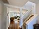 Bright foyer with hardwood flooring, staircase, and view into the living room at 7277 Sweetgrass Blvd, Hanahan, SC 29410