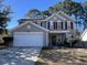 Charming two-story home with gray siding, red shutters, two car garage, and a well-maintained front lawn at 7277 Sweetgrass Blvd, Hanahan, SC 29410