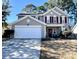Charming two-story home with gray siding, red shutters, two car garage, and a well-maintained front lawn at 7277 Sweetgrass Blvd, Hanahan, SC 29410