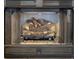 Close-up of a fireplace featuring realistic-looking logs and a grate front at 7277 Sweetgrass Blvd, Hanahan, SC 29410