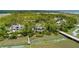 Aerial view of a home surrounded by marsh and waterways, nestled among lush trees at 79 Trailing Vine Way, Kiawah Island, SC 29455