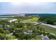 Expansive aerial view of 79 Trailing Vine showcasing the golf course, marsh views, and tree coverage at 79 Trailing Vine Way, Kiawah Island, SC 29455
