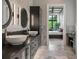 Well-lit bathroom with double sinks, modern light fixtures, and an open doorway to the bedroom at 79 Trailing Vine Way, Kiawah Island, SC 29455
