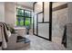 Elegant bathroom with a freestanding tub, tiled walk-in shower, and a large window showcasing greenery at 79 Trailing Vine Way, Kiawah Island, SC 29455