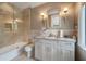 Bright bathroom with a tub and shower combo, decorative sconce lighting, and granite vanity with updated sink fixtures at 79 Trailing Vine Way, Kiawah Island, SC 29455