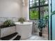 Close up of luxurious freestanding bathtub with view of the backyard trees and greenery at 79 Trailing Vine Way, Kiawah Island, SC 29455