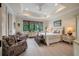 Bedroom features a tray ceiling, recessed lighting, large windows, and comfortable seating area at 79 Trailing Vine Way, Kiawah Island, SC 29455