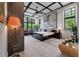 Spacious bedroom with black ceiling beams, large windows, and a view of backyard greenery at 79 Trailing Vine Way, Kiawah Island, SC 29455