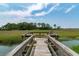 Wooden dock featuring seating area overlooking marshlands with lush scenery and calm water at 79 Trailing Vine Way, Kiawah Island, SC 29455
