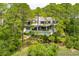 Beautiful home exterior with lush greenery and a private deck surrounded by mature trees at 79 Trailing Vine Way, Kiawah Island, SC 29455