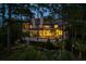 Stunning home exterior surrounded by trees, with a lighted outdoor seating area at 79 Trailing Vine Way, Kiawah Island, SC 29455