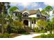 Beautiful home exterior with a lush landscaped yard and circular drive with mature palm trees at 79 Trailing Vine Way, Kiawah Island, SC 29455