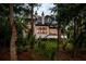 Home exterior surrounded by mature trees and palm trees with large windows at 79 Trailing Vine Way, Kiawah Island, SC 29455
