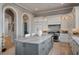 Spacious kitchen with white cabinets, a gray island with marble countertop, stainless steel appliances, and natural light at 79 Trailing Vine Way, Kiawah Island, SC 29455