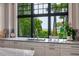Bright kitchen sink with a scenic view of lush greenery and natural light streaming through the window at 79 Trailing Vine Way, Kiawah Island, SC 29455