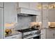 Close up of range with marble backsplash and stainless steel hood and appliances at 79 Trailing Vine Way, Kiawah Island, SC 29455