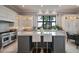 Well-lit kitchen featuring white cabinets, a gray island with marble countertop, stainless steel appliances, and a large window at 79 Trailing Vine Way, Kiawah Island, SC 29455