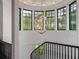 Elegant curved staircase featuring a stunning chandelier and an abundance of natural light from surrounding windows at 79 Trailing Vine Way, Kiawah Island, SC 29455