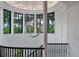 Bright stairwell features a modern chandelier, black railings, and floor-to-ceiling windows with backyard views at 79 Trailing Vine Way, Kiawah Island, SC 29455