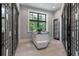 Bright walk-in closet with custom shelving, a central island, and a large window offering natural light at 79 Trailing Vine Way, Kiawah Island, SC 29455