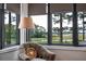 Bright window seat with scenic backyard views, accent chair, and roller shades for light control at 79 Trailing Vine Way, Kiawah Island, SC 29455