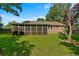 Expansive backyard showcasing a well-maintained lawn and a screened-in porch, ideal for outdoor enjoyment at 8204 Pleasant Ridge Dr, Charleston, SC 29420