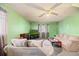 Green living room featuring a comfortable sofa, ceiling fan, and a flatscreen television at 8204 Pleasant Ridge Dr, Charleston, SC 29420