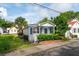 Charming home with blue door and shutters, lush landscaping, and inviting front porch at 9 F St, Charleston, SC 29403
